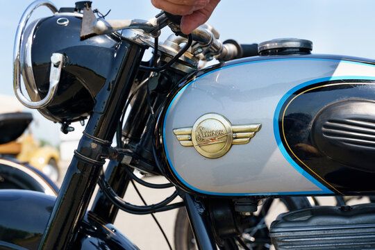 A Simson AWO Sport motorcycle parked in front of a Burgenland classic.