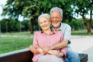 woman man senior couple happy retirement together elderly hug active bonding park outdoor sitting...