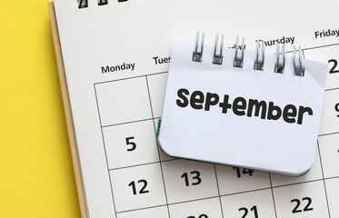 The word SEPTEMBER in a notebook on a calendar.