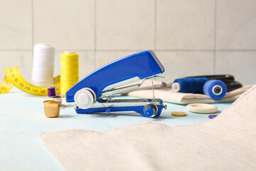 Manual sewing machine with different supplies on gradient table near wall