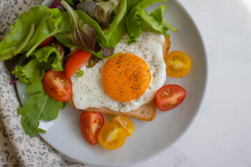 Bread with fried egg, tomatoes, lettuce