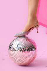 Fashionable woman with disco ball on pink background