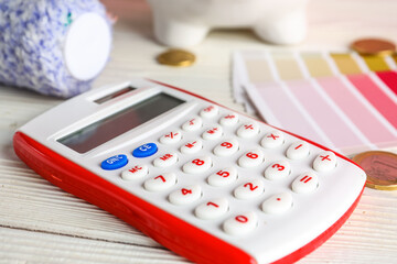 Calculator and color samples on white wooden table, closeup. Renovation budget concept