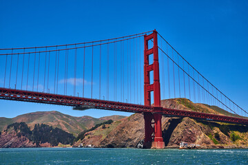 Close up of Golden Gate Bridge with bright summer day with blue skies and choppy bay waters