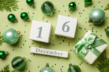 Calendar with date 16 DECEMBER and Christmas decor on green background