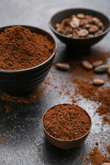 Bowls with cocoa powder on black background