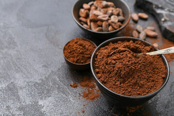 Bowls with cocoa powder on black background