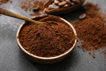 Bowl with cocoa powder on black background