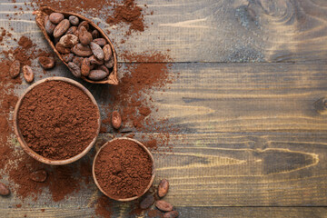 Bowls with cocoa powder and beans on wooden background