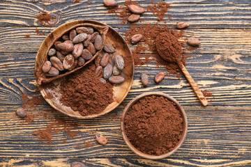 Bowl with cocoa powder and beans on wooden background