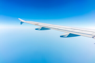 View from the airplane window at a beautiful cloudy sky and the airplane wing