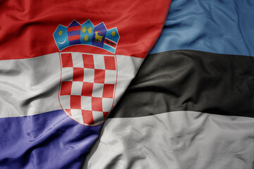 big waving national colorful flag of croatia and national flag of estonia .