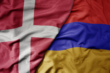 big waving national colorful flag of denmark and national flag of armenia .