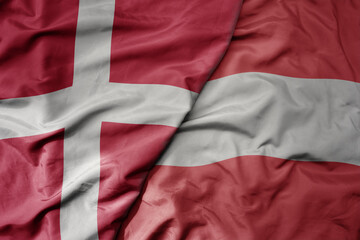 big waving national colorful flag of denmark and national flag of austria .
