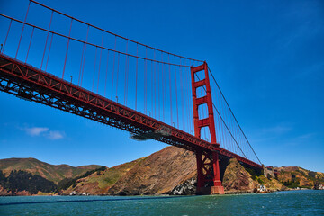 Underside and side view of Golden Gate Bridge with choppy San Francisco Bay waters