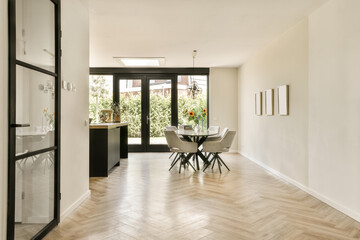 a dining room with wood flooring and black glass doors leading to the kitchen area in this home,...