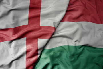 big waving national colorful flag of england and national flag of hungary .