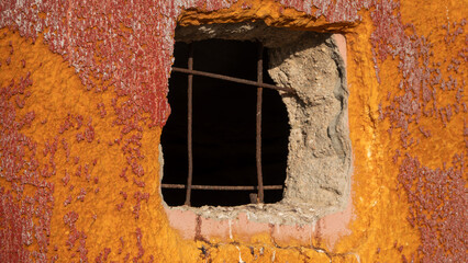rusty window bars on old dirty orange-red painted concrete wall background
