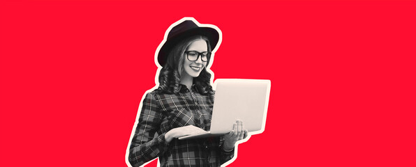 Portrait of modern happy smiling young woman working with laptop wearing eyeglasses on red background