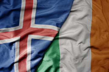 big waving national colorful flag of icelandic and national flag of ireland .