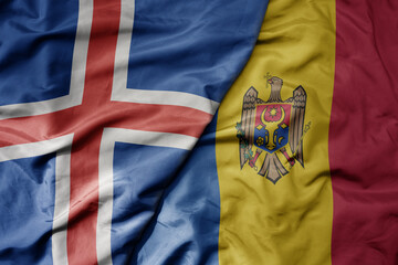big waving national colorful flag of icelandic and national flag of moldova .