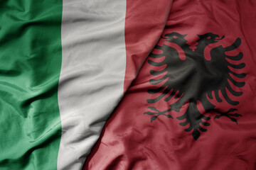 big waving national colorful flag of italy and national flag of albania .