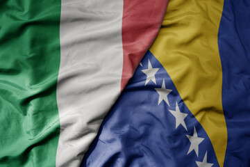 big waving national colorful flag of italy and national flag of bosnia and herzegovina .