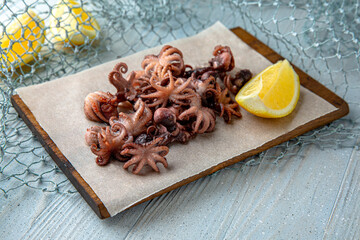 Fried baby octopus on a blue background. Mediterranean Kitchen. Sea mood menu.