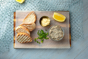 Forshmak with crispy toast. Herring with butter on a blue background. Mediterranean Kitchen. Sea mood menu.