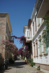 Fassade sanierter alter Häuser in Weiß und Naturfarben im Sommer bei blauem Himmel und...