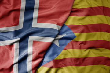 big waving national colorful flag of norway and national flag of catalonia .
