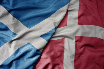big waving national colorful flag of scotland and national flag of denmark .