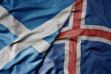 big waving national colorful flag of scotland and national flag of iceland .