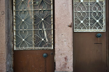 Schmiedeeisen am Fenster einer Stahltür in Braun mit Rost und Patina eines Altbau im Sommer in den...