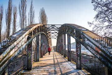 man walking over bridge in winter