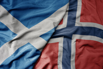 big waving national colorful flag of scotland and national flag of norway .