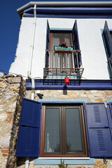 Sanierter Altbau mit Gästezimmer für Touristen in Weiß und Blau mit Balkon im Sommer bei blauem...