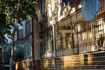 Poster Komplett vergitterte Veranda eines Wohnhaus in Beige und   Naturfarben im Licht der Abendsonne in Altinoluk am Golf von Edremit am Ägäischen Meer in der Provinz Balikesir in der Türkei © Martin Debus