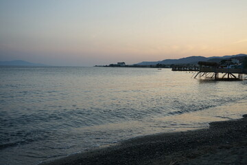 Blick vom Strand in Altinoluk mit Beach Club im romantischen Licht der untergehenden Sonne auf den...