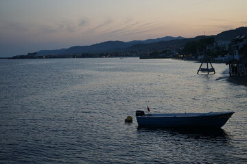 Blick vom Strand in Altinoluk mit Beach Club im romantischen Licht der untergehenden Sonne auf den...