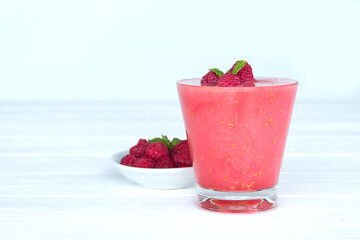 Raspberry smoothie red colorful fruit juice milkshake blend beverage healthy high protein the taste yummy In glass drink episode morning on white wood background.