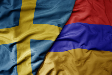 big waving national colorful flag of sweden and national flag of armenia .