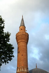 Altes Minarett der Yigit Kohne Moschee im Sommer mit Wolken bei Sonnenschein in der Altstadt von...