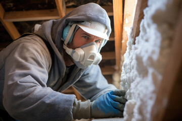 Hunched and working inside a tight space this insulation worker keeps the home warm. His strong arms and tough spirit ensure that his work is excellent and all homes are comfortable.
