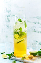 Homemade iced tea with lime, mint and brown sugar
in a glass bottle