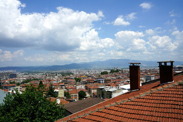 Panoramablick über alte rote Ziegeldächer auf die Stadt und das Uludag Gebirge aus einem Café...