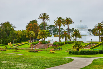 Exterior Conservatory of Flowers with people in park with flower beds