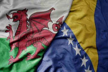 big waving national colorful flag of wales and national flag of bosnia and herzegovina .