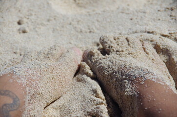 Fototapeta na wymiar Sandy feet by the beach