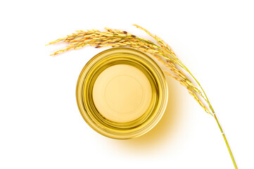 Glass bowl of rice bran oil extract with paddy on white . Top view - 637610453